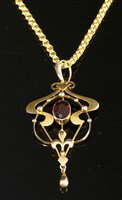 Lot 653 - An Edwardian gold garnet set Art Nouveau pendant