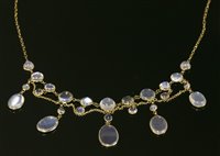 Lot 107 - An Edwardian gold moonstone and sapphire swag and fringe necklace