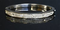 Lot 540 - A flat section diamond set hinged bangle