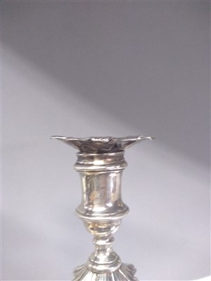 Lot 100 - A pair of George II silver candlesticks