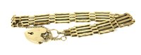 Lot 15 - A 9ct gold four row gate link bracelet with padlock