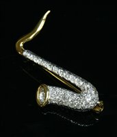 Lot 492 - An 18ct yellow and white gold diamond set saxophone brooch