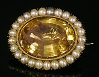 Lot 15 - A Georgian gold foiled back citrine and split pearl brooch/pendant