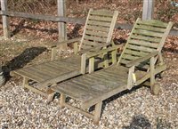 Lot 1078 - A pair of teak garden loungers with adjustable slatted backs