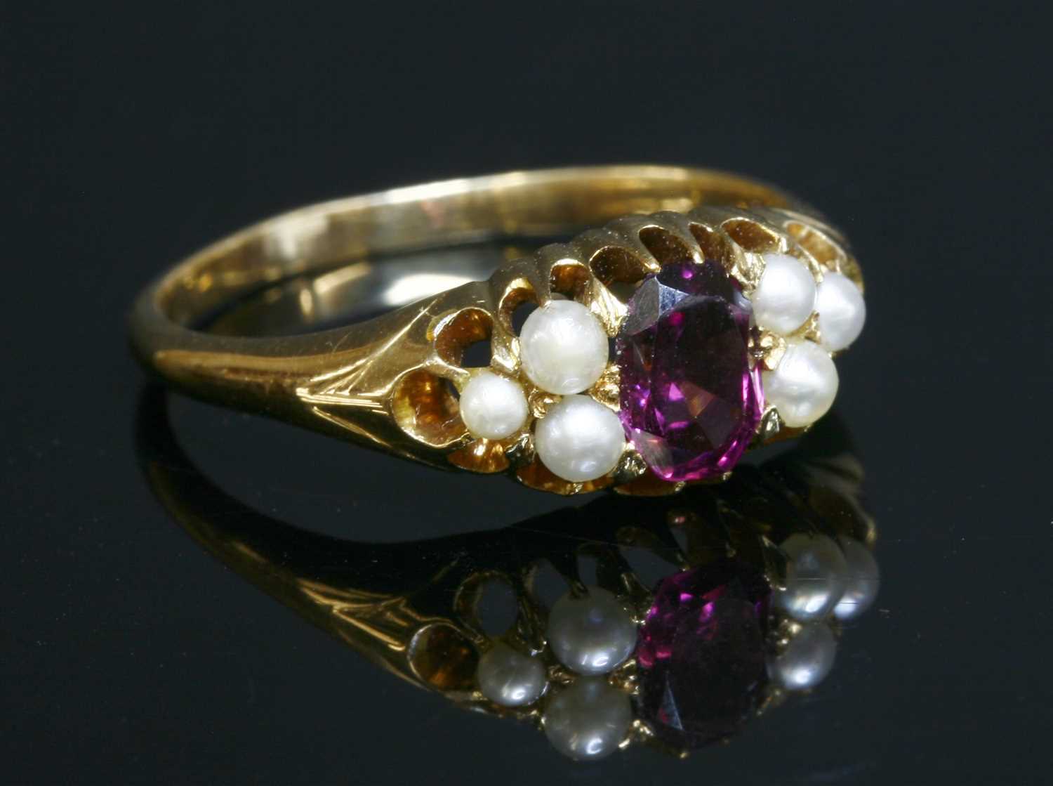 Lot 105 - An Edwardian garnet and pearl boat-shaped ring