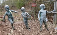 Lot 1064 - Three faux lead garden figures of young boys