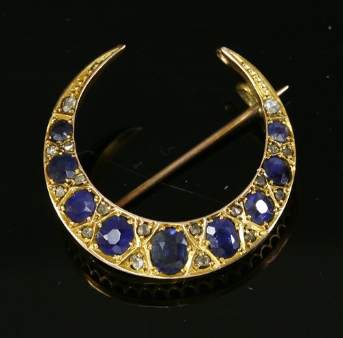 Lot 55 - An Edwardian sapphire and diamond closed crescent brooch