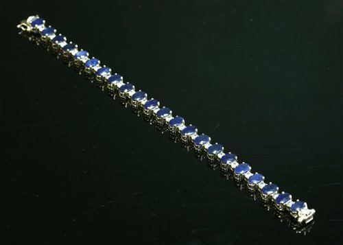 Lot 296 - An 18ct white gold sapphire and diamond line bracelet