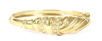 Lot 78 - A 9ct gold diamond hinge bangle