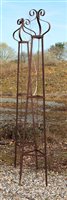 Lot 1051 - A pair of wrought iron garden obelisks of pyramidal form with crown finials, 229 cm high x 38 wide