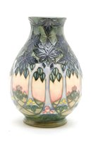 Lot 240 - A modern Moorcroft vase, decorated with trees in a landscape, stamped and painted marks to the base, 19cm high
