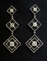 Lot 565 - A pair of white gold three stone diamond drop earrings