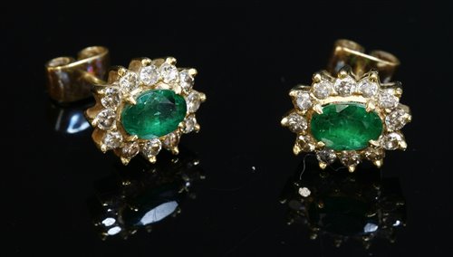 Lot 348 - A pair of gold, emerald and diamond oval cluster earrings
