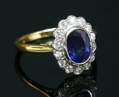 Lot 322 - An 18ct yellow and white gold sapphire and diamond oval cluster ring