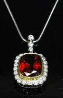 Lot 506 - An 18ct yellow and white gold, garnet and diamond cluster pendant