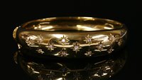 Lot 409 - An 18ct gold diamond set oval hinged bangle