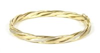 Lot 198 - A 9ct two colour gold twisted design hinge bangle