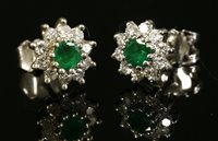 Lot 357 - A pair of 18ct white gold emerald and diamond circular cluster earrings