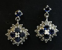 Lot 509 - A pair of 18ct white gold diamond and sapphire cluster drop earrings