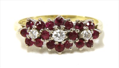 Lot 28 - An 18ct gold diamond and ruby triple cluster ring