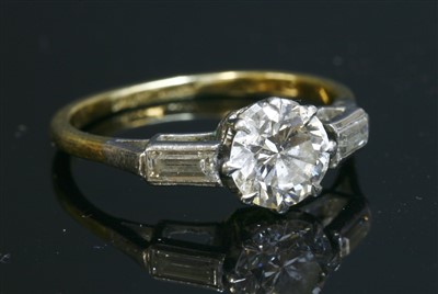 Lot 175 - A single stone diamond ring with baguette cut diamonds shoulders