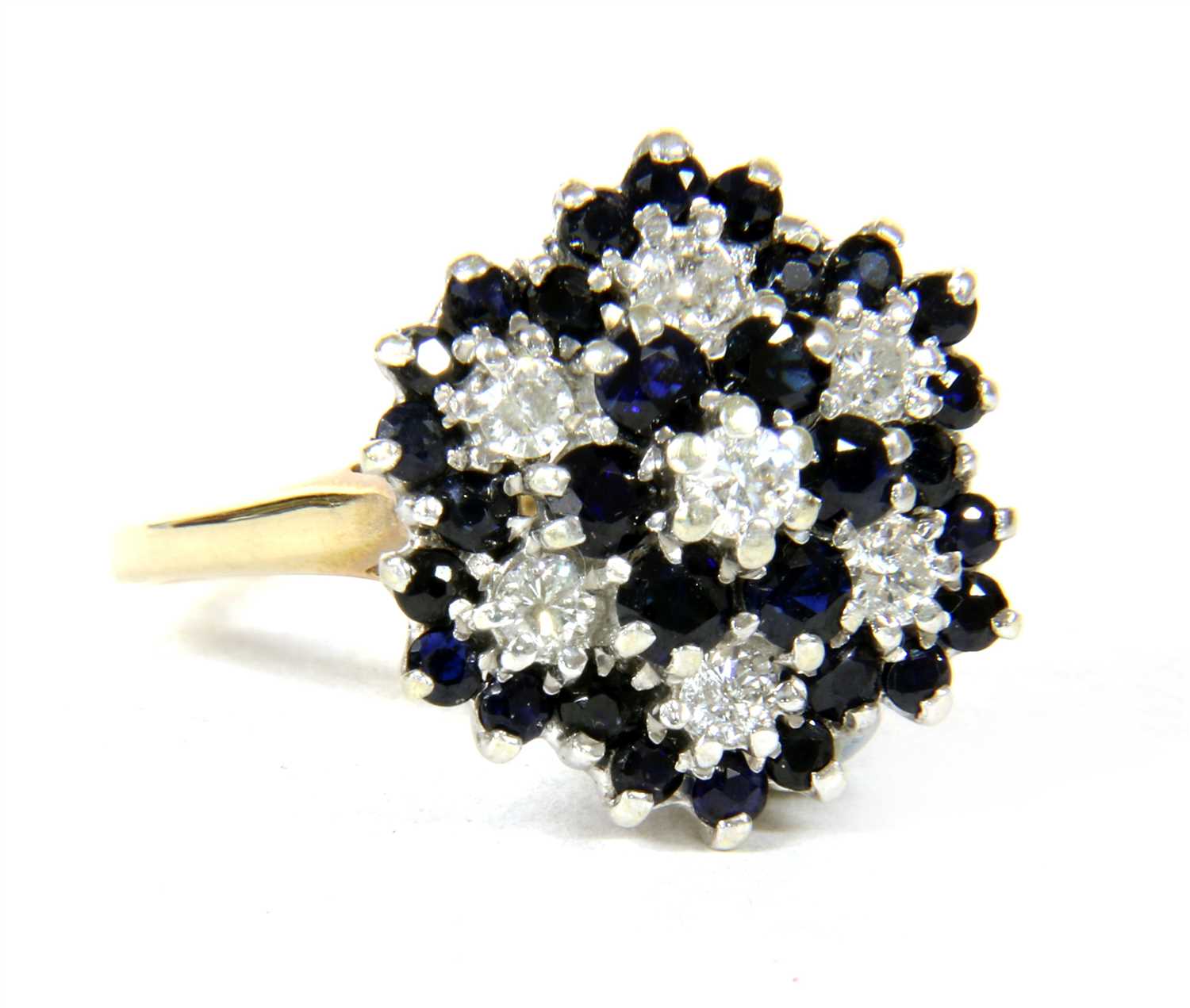 Lot 11 - A 9ct gold diamond and sapphire four tier cluster ring
