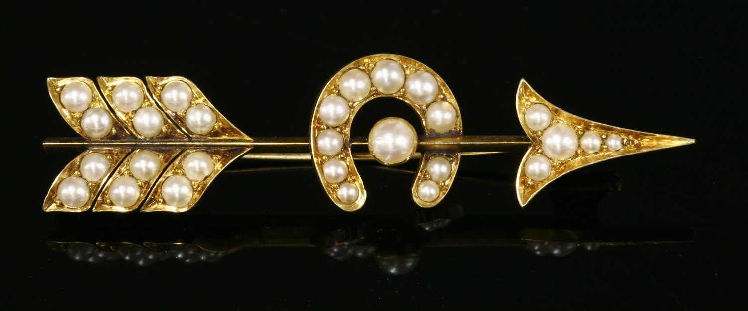 Lot 81 - A late Victorian gold and split pearl arrow and horseshoe brooch