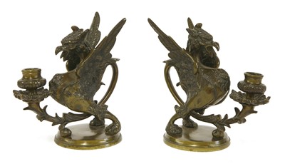 Lot 501 - A pair of dark brown patinated bronze griffin/wyvern candlesticks