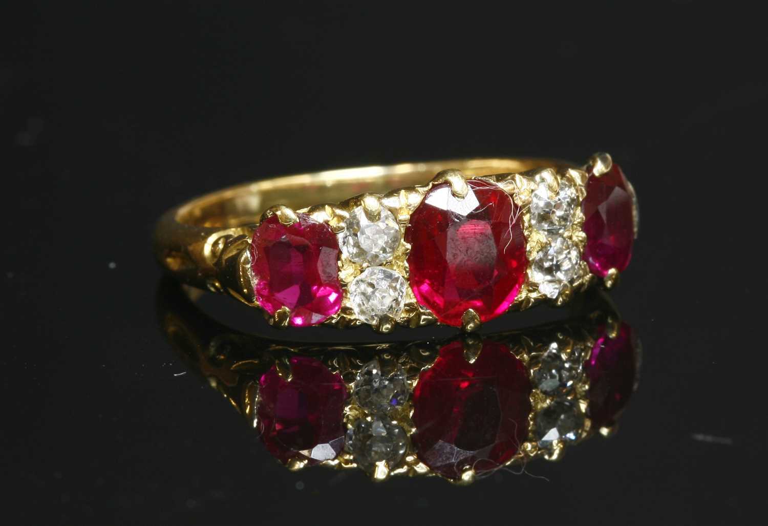 Lot 63 - An 18ct gold synthetic ruby and diamond carved head ring