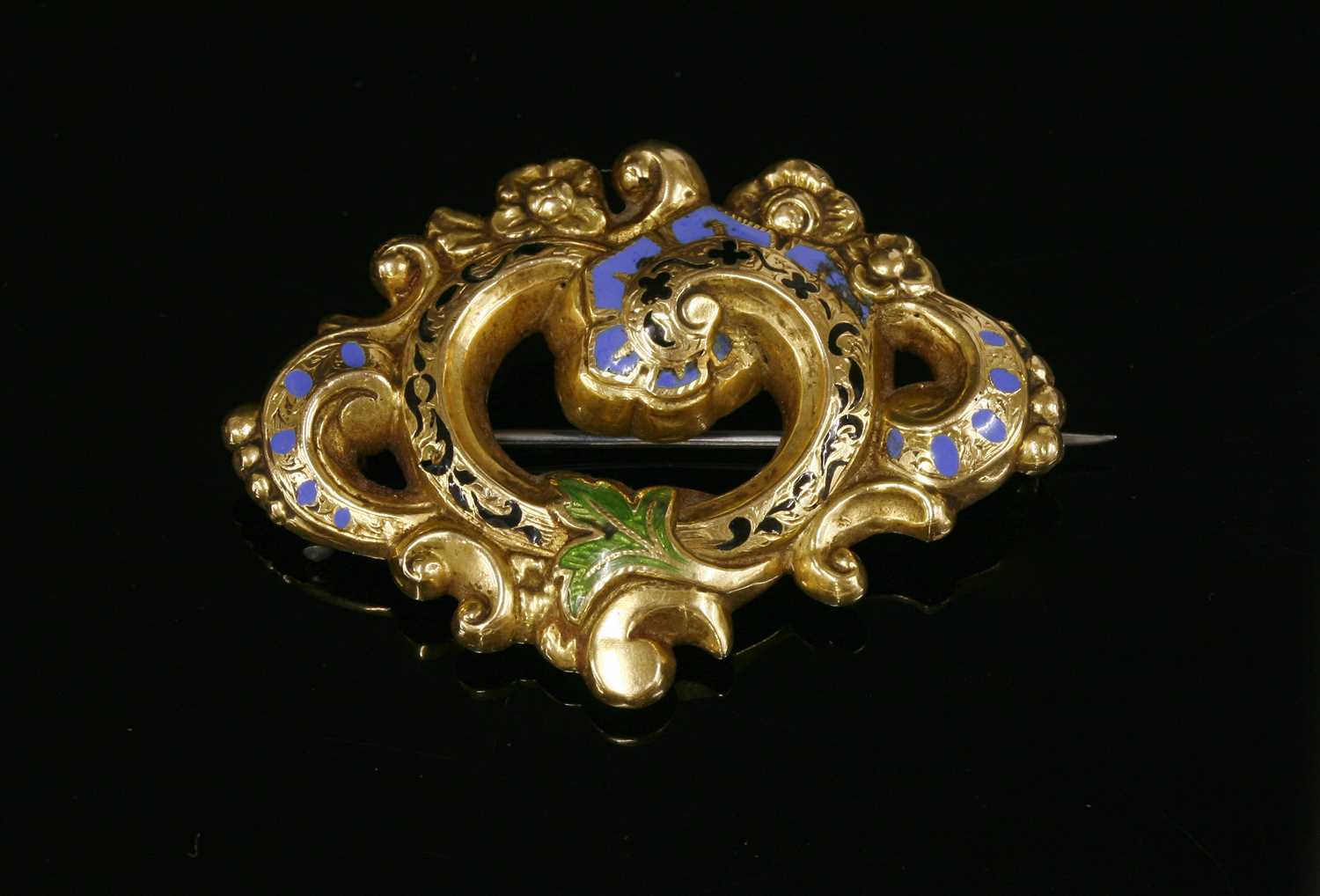 Lot 19 - A Victorian gold and enamel scrolling foliate brooch