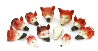 Lot 699 - Eleven various pottery fox mask stirrup cups