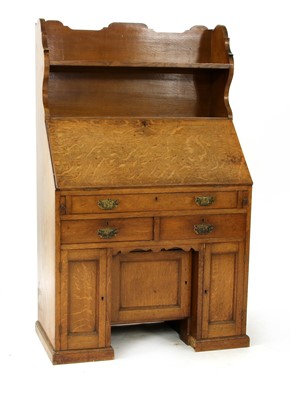 Lot 257 - An early 20th century oak kneehole bureau bookcase