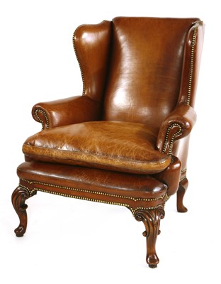 Lot 567 - A leather wing back armchair