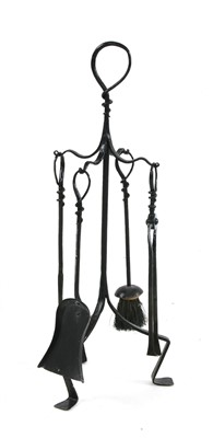 Lot 406 - An Arts and Crafts wrought iron companion set and stand