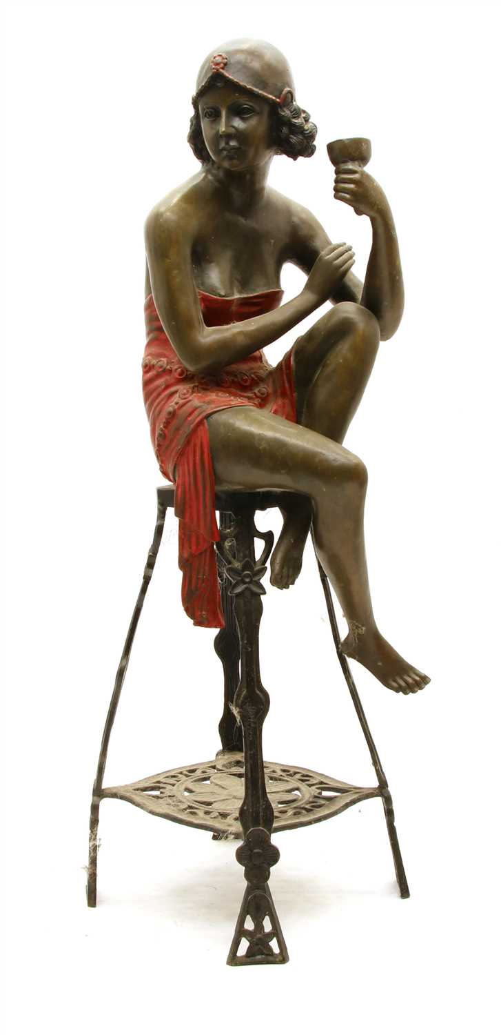 Lot 162 - A bronze figure of an Art Deco flapper girl drinking champagne seated on bar stool