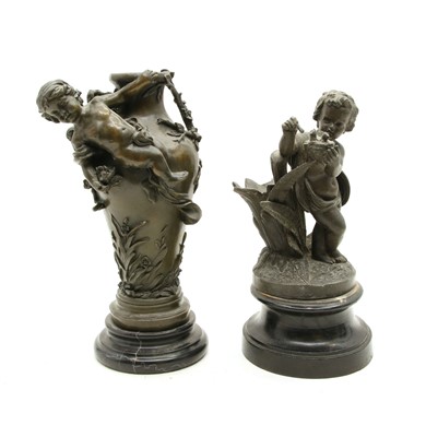 Lot 258 - A bronze figure depicting a putto adorning an urn