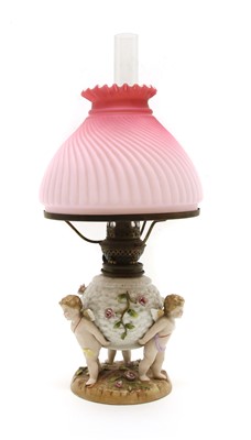 Lot 223 - A porcelain three cherub oil lamp