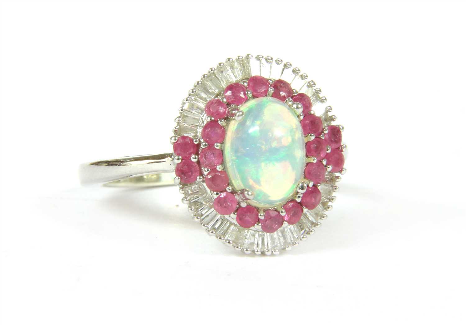 Lot 24 - A white gold opal, ruby and diamond oval cluster ring