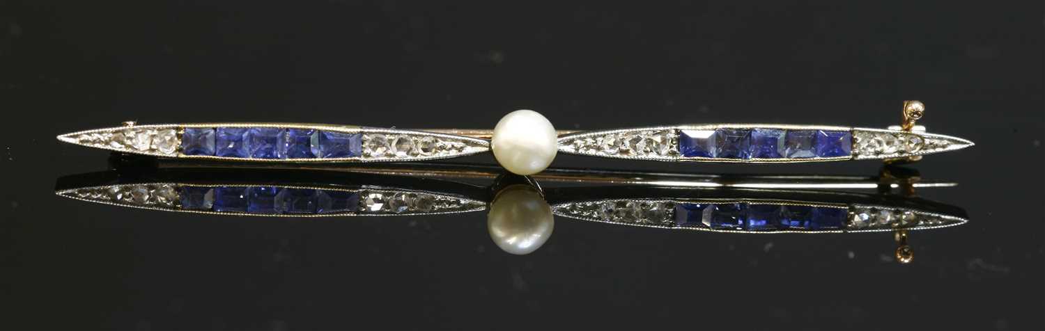 Lot 160 - An Art Deco gold and platinum pearl, sapphire and diamond propeller form bar brooch, c.1920