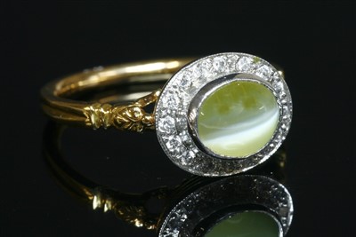 Lot 337 - An 18ct yellow and white gold chrysoberyl cat's eye and diamond oval cluster ring