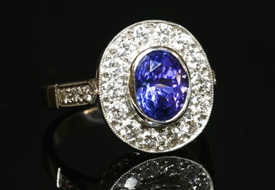 Lot 488 - An 18ct white gold tanzanite and diamond oval cluster ring
