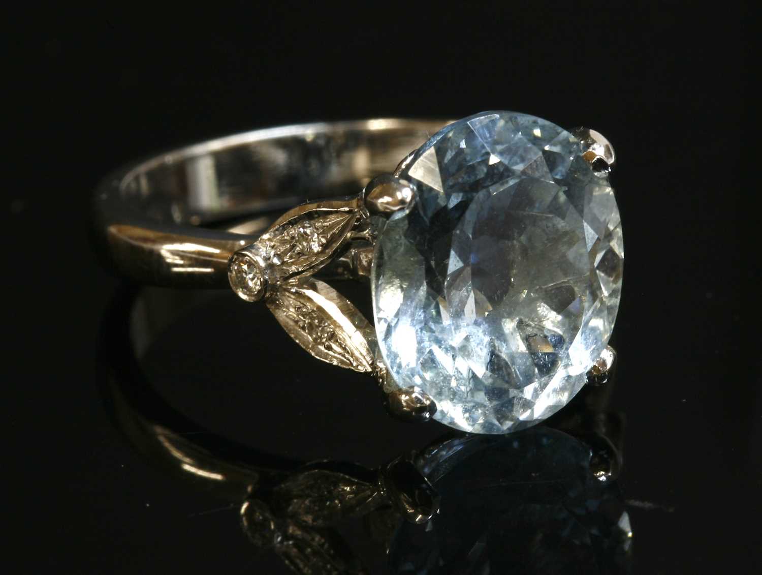 Lot 438 - An 18ct white gold single stone aquamarine ring with diamond set shoulders