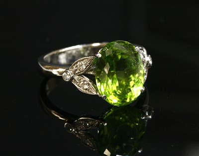 Lot 529 - An 18ct white gold single stone peridot ring with diamond set shoulders