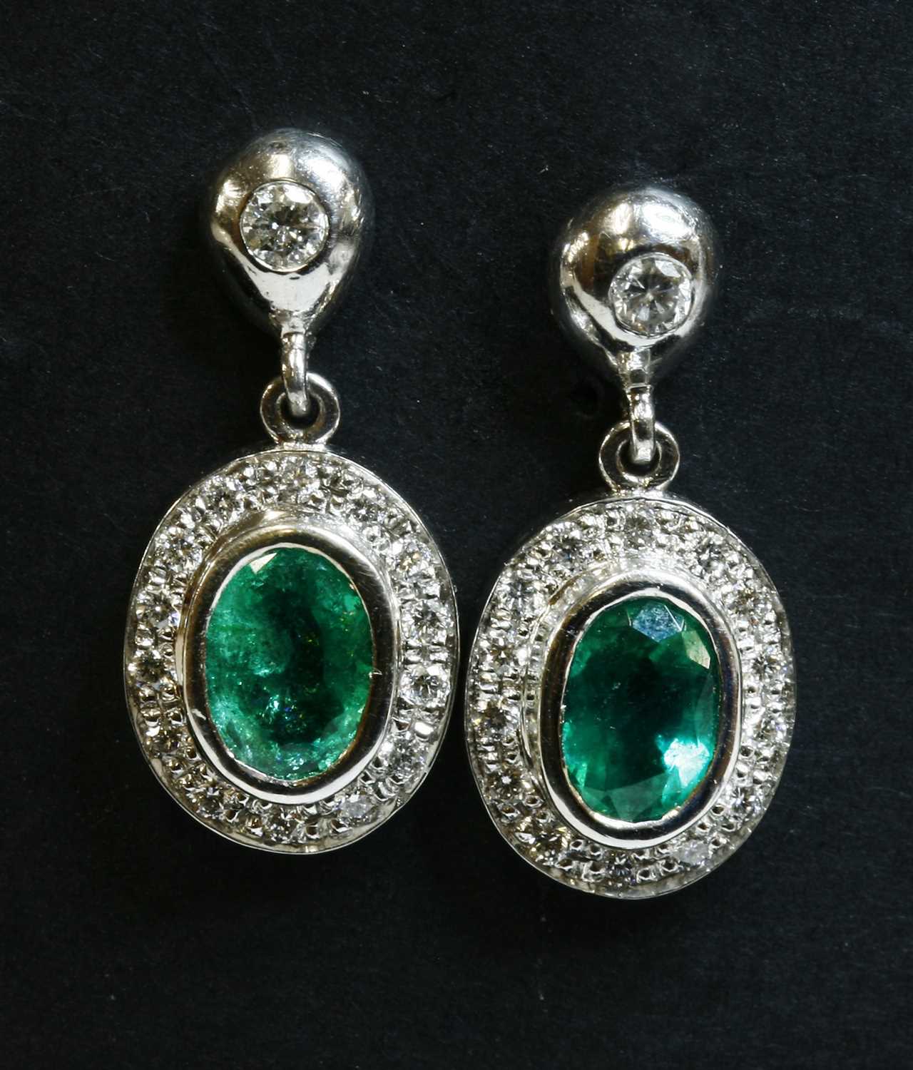 Lot 454 - A pair of 18ct white gold emerald and diamond cluster drop earrings