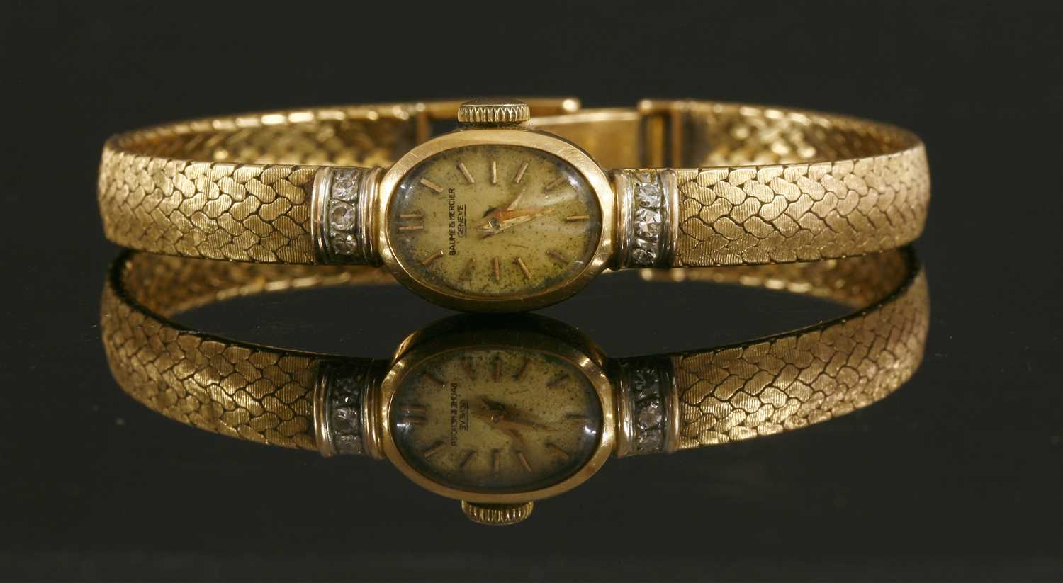 Lot 247 - A ladies' 18ct gold Baume & Mercier diamond set mechanical bracelet watch
