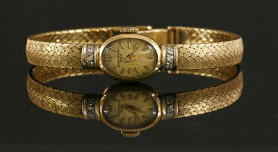 Lot 247 - A ladies' 18ct gold Baume & Mercier diamond set mechanical bracelet watch