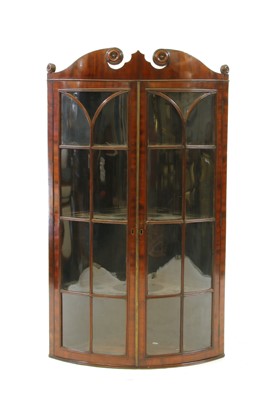 Lot 392 - A George III mahogany quarter eliptical corner cabinet