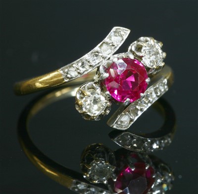 Lot 64 - A three stone synthetic ruby and diamond crossover ring