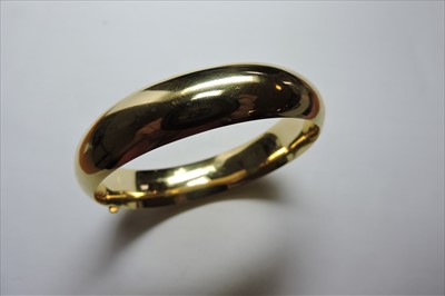 Lot 312 - A hollow 'D' section hinged gold bangle