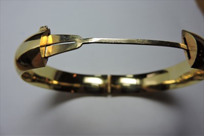 Lot 312 - A hollow 'D' section hinged gold bangle